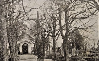 Dřevěný kříž uprostřed hlavní hřbitovní cesty